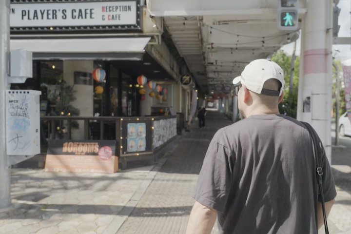 個性豊かな店が軒を連ねるコザのパークアベニューを案内する宮島さん