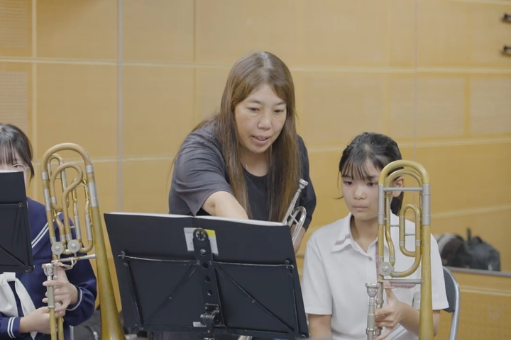 吹奏楽部の部員を指導する田中さん