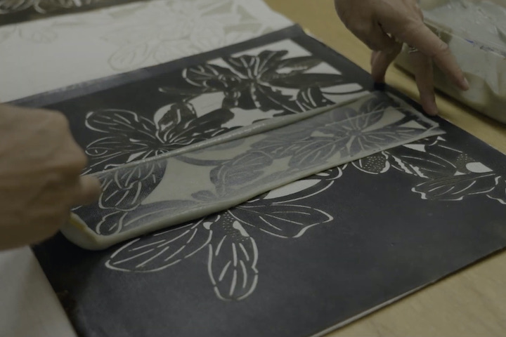 手彫りされた型紙に手作りの糊を置く、防染の為の工程