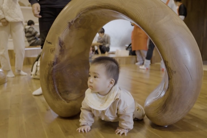倒木した樹齢300年の琉球松で作られたトンネルで遊ぶ子供