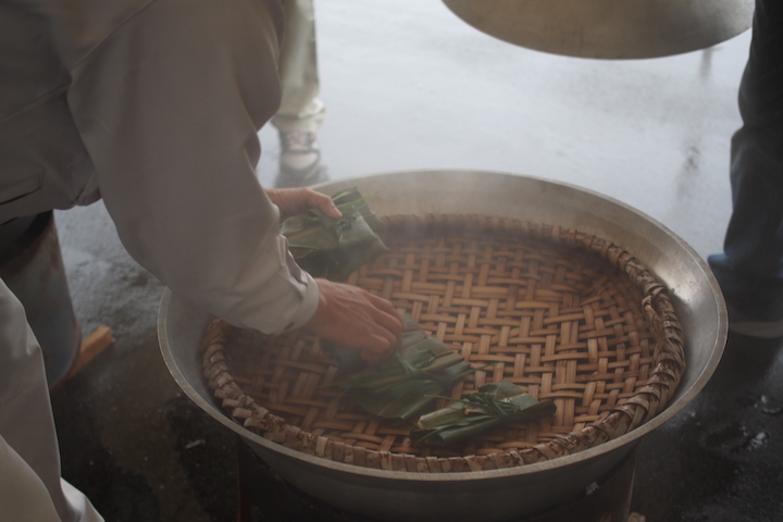 鍋にバーキ（竹かご）を敷き、その上にムーチーをどんどん並べていきます