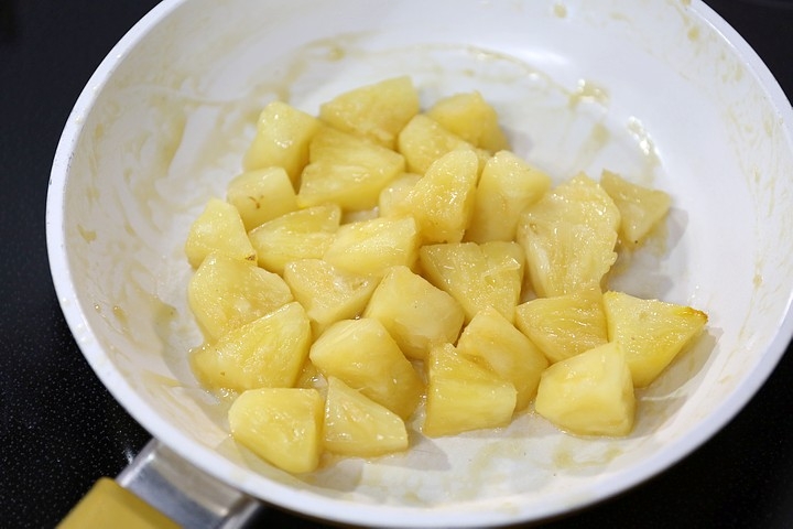 フライパンにバターを入れてパイナップルを炒める